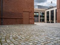 the walkway between two red bricks and a building with the outside entrance to it with a bench