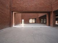 a view of a brick hallway with multiple openings, and sunlight from one doorway, through the floor