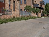 the street is lined with bricks near buildings and trees in front of it for people to walk