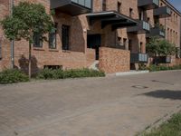 the street is lined with bricks near buildings and trees in front of it for people to walk