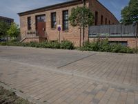 the street is lined with bricks near buildings and trees in front of it for people to walk