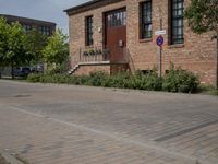 the street is lined with bricks near buildings and trees in front of it for people to walk