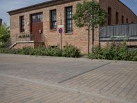 the street is lined with bricks near buildings and trees in front of it for people to walk