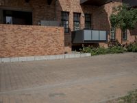 the street is lined with bricks near buildings and trees in front of it for people to walk