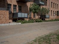 the street is lined with bricks near buildings and trees in front of it for people to walk