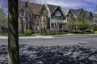 a large brick mansion surrounded by a leafy tree on the corner of a road