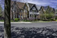 a large brick mansion surrounded by a leafy tree on the corner of a road