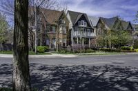 a large brick mansion surrounded by a leafy tree on the corner of a road