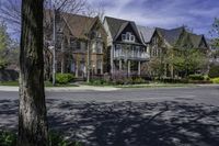 a large brick mansion surrounded by a leafy tree on the corner of a road