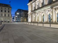 a brick road with a couple people walking on it at night time in europe - city square