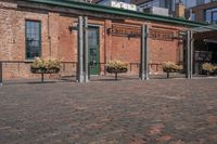 large bricks sitting on a brick sidewalk in front of a building with a bunch of flower pots