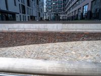 the brick sidewalk in front of two buildings has a few bricks on it near it