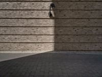 a brick sidewalk and an outside area with a wall of bricks and a street light