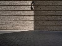 a brick sidewalk and an outside area with a wall of bricks and a street light