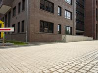 a brick street with a no parking sign on it in front of the building that is a row of other brick buildings