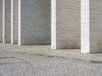 this is a photo of a brick street in front of a building that has columns and other things on the ground in front of it