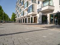 brick walk way through an apartment complex in the city of london, england, with cars driving by and parked bikes