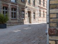 this brick walkway features a stone brick wall and tree lined building with a blue sign stating to have closed all year