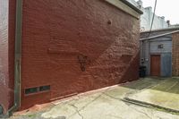 a brick wall with a drawing on it of a dog on the sidewalk by buildings