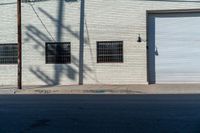 the side of a brick building with windows and graffiti on it's side in the sun