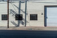 the side of a brick building with windows and graffiti on it's side in the sun