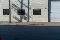 the side of a brick building with windows and graffiti on it's side in the sun