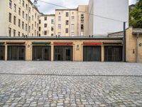 an empty parking garage in a city courtyard area on a cloudy day by a building