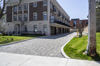 a bricked driveway in front of a large building and a fire hydrant in the middle of it