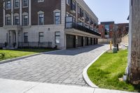 a bricked driveway in front of a large building and a fire hydrant in the middle of it