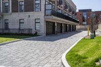 a bricked driveway in front of a large building and a fire hydrant in the middle of it