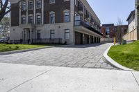 a bricked driveway in front of a large building and a fire hydrant in the middle of it