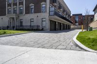 a bricked driveway in front of a large building and a fire hydrant in the middle of it