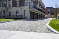 a bricked driveway in front of a large building and a fire hydrant in the middle of it