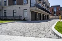 a bricked driveway in front of a large building and a fire hydrant in the middle of it