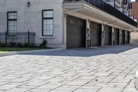 a bricked driveway in front of a large building and a fire hydrant in the middle of it