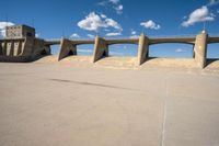 a man on a skateboard is in the air with some concrete bridges and a ramp