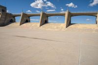 a man on a skateboard is in the air with some concrete bridges and a ramp