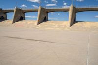 a man on a skateboard is in the air with some concrete bridges and a ramp