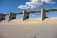 a man on a skateboard is in the air with some concrete bridges and a ramp