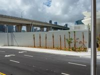 a freeway is shown passing a building and palm trees on the other side of it