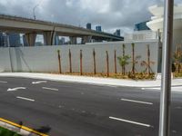 a freeway is shown passing a building and palm trees on the other side of it