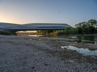 there are two very long bridges that are above the river shore at dusk here, and you can see how close them are