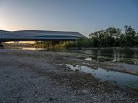 there are two very long bridges that are above the river shore at dusk here, and you can see how close them are