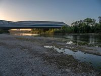 there are two very long bridges that are above the river shore at dusk here, and you can see how close them are