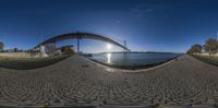 a fisheye view of a bridge that spans over water at a large dock,