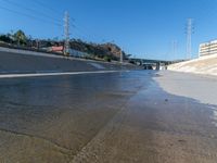 an urban roadway filled with puddles of water on the side of the street and on the side