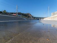 an urban roadway filled with puddles of water on the side of the street and on the side