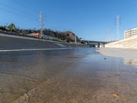 an urban roadway filled with puddles of water on the side of the street and on the side