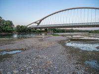 there are two very long bridges that are above the river shore at dusk here, and you can see how close them are