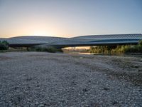 there are two very long bridges that are above the river shore at dusk here, and you can see how close them are